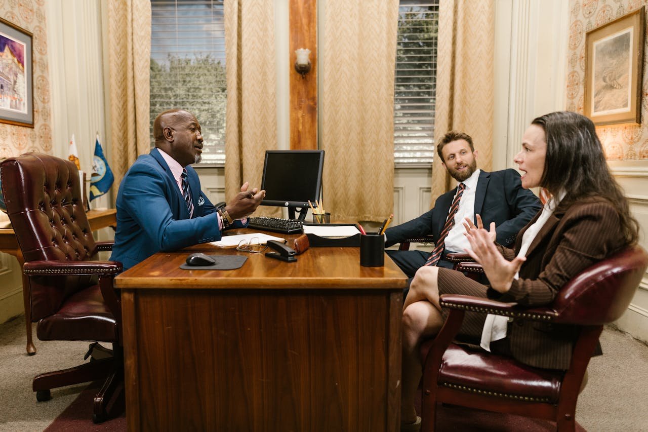 About Three attorneys in a legal discussion at a well-appointed law office.
